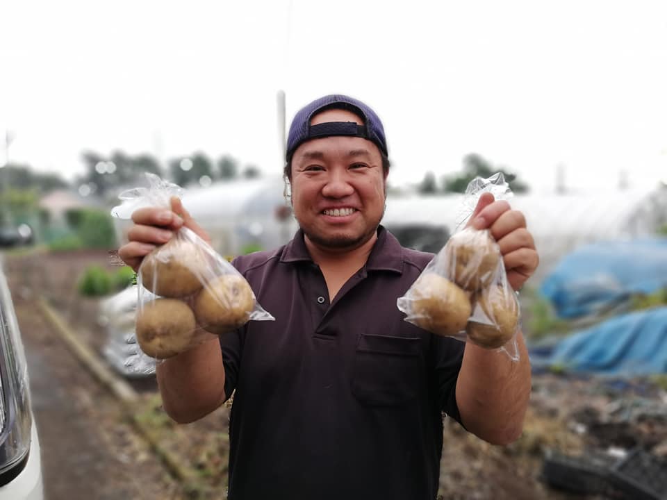 6月受け渡しのジャガイモを持つ三鷹市牟礼の高橋喜宏さん